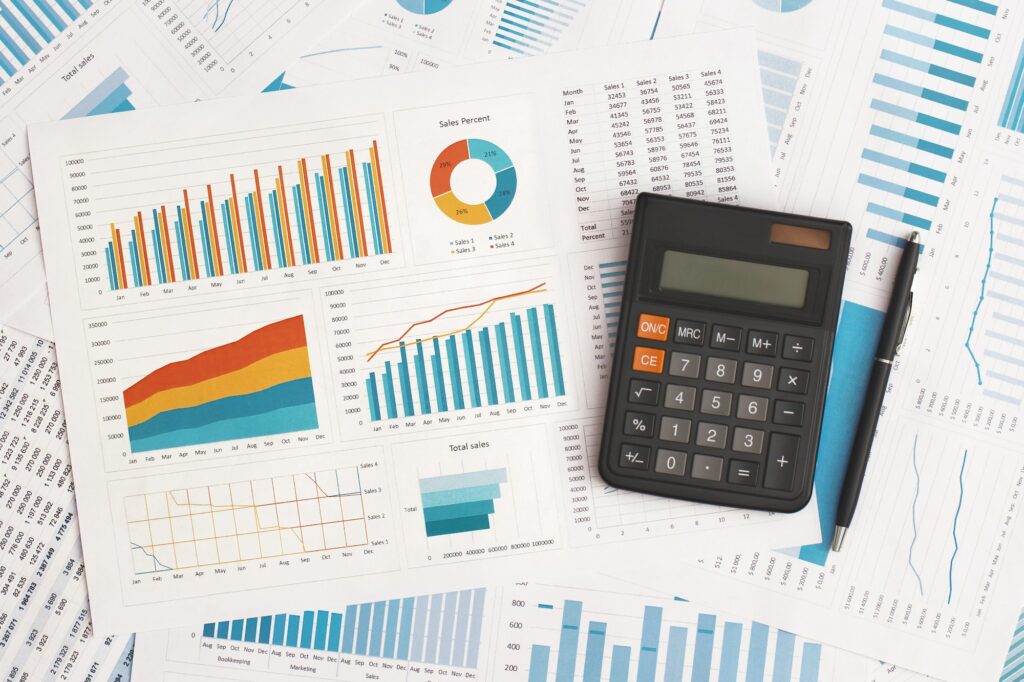Business graphs, charts and calculator on table. Financial development