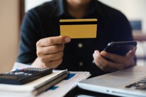 Closeup Men Holding Hand Credit Card.Businessman Use Smartphone Online Payments Shopping.