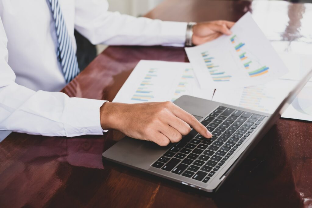 The businessman hand sits at their desks and calculates financial graphs showing the results