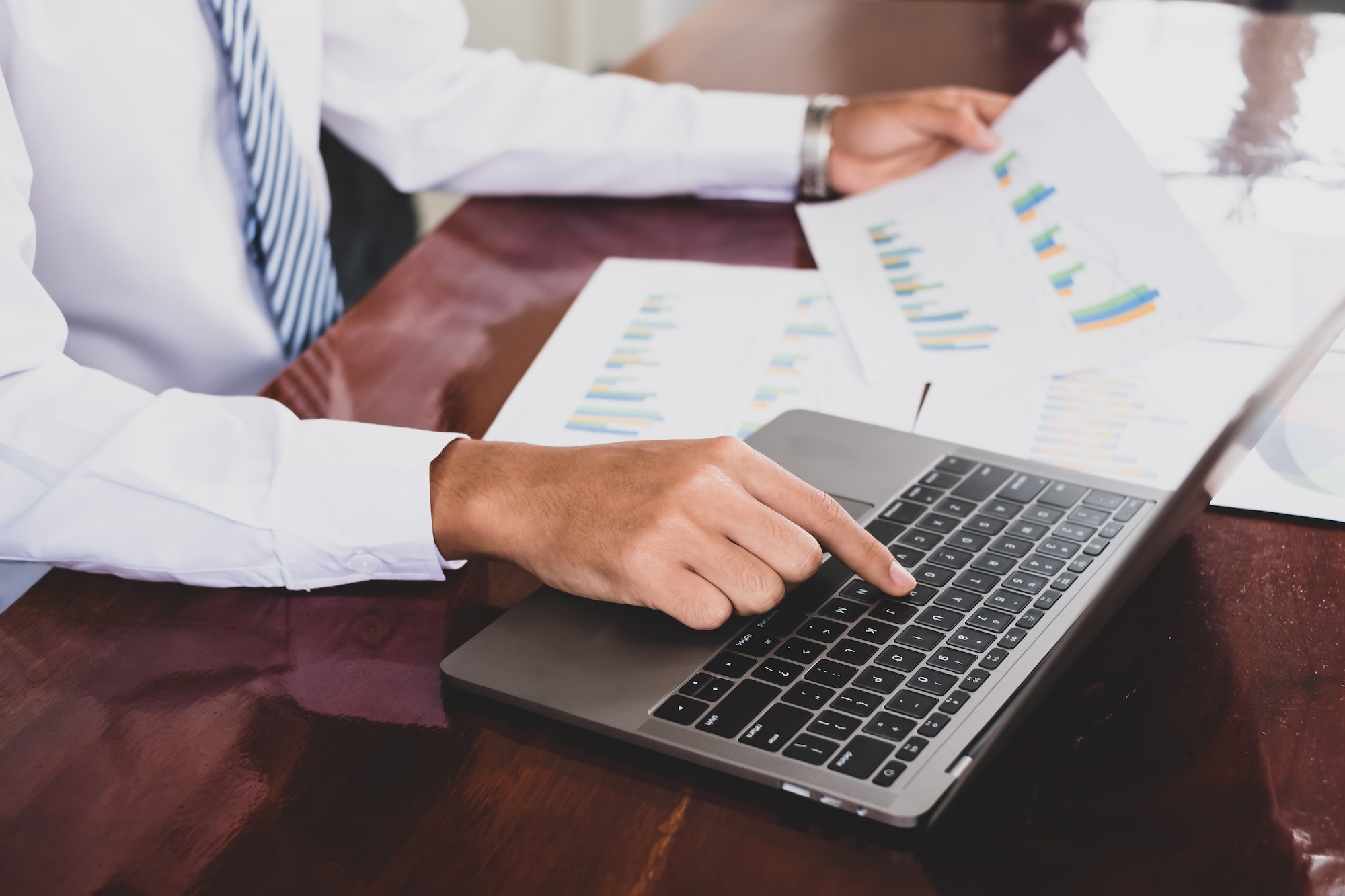 The businessman hand sits at their desks and calculates financial graphs showing the results